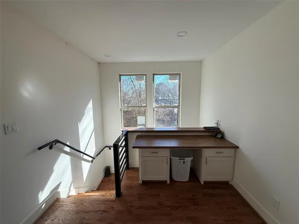 a view of a workspace with furniture and a window