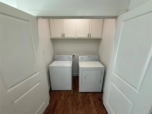 a utility room with wooden floor washer and dryer