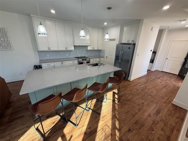 a kitchen with a table chairs refrigerator and microwave