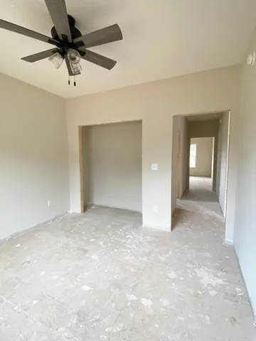 a view of a big room with a chandelier fan and closet
