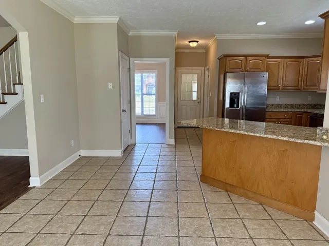 a kitchen with granite countertop a rug and a view of living room