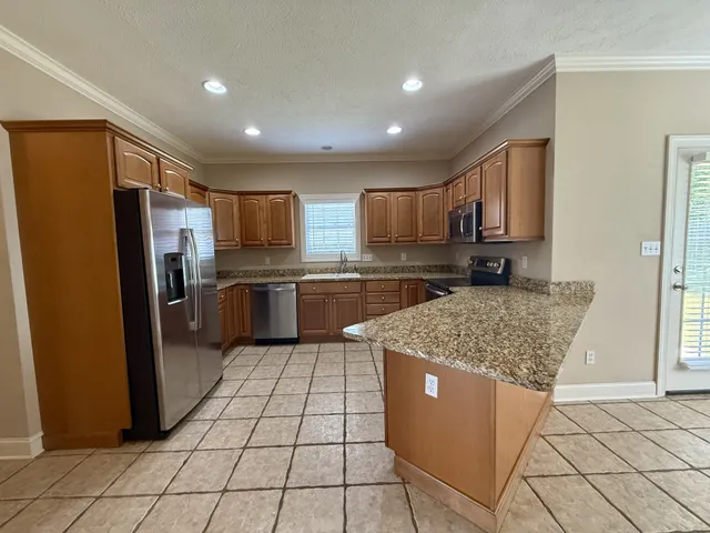 a kitchen with stainless steel appliances granite countertop a refrigerator sink and stove