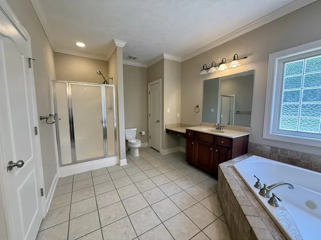 a bathroom with a tub a double vanity sink and mirror