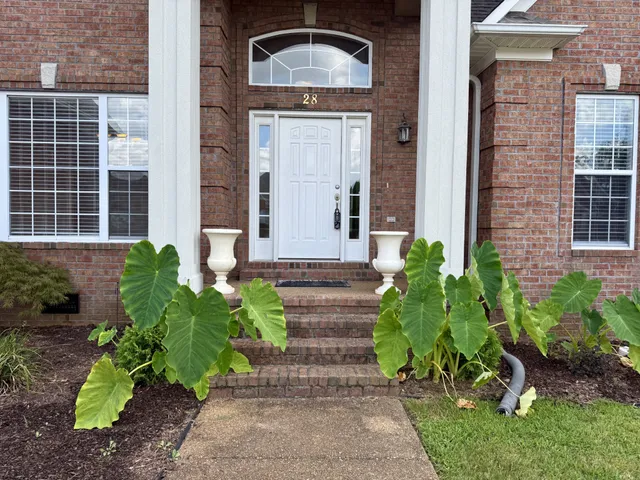 a front view of a house with a garden