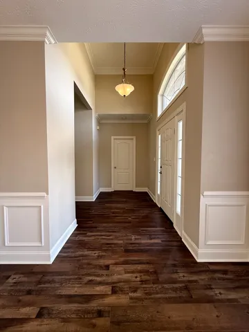 a view of a hallway with wooden floor and staircase