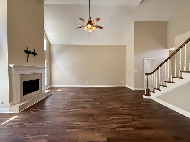 a view of empty room with wooden floor and fireplace