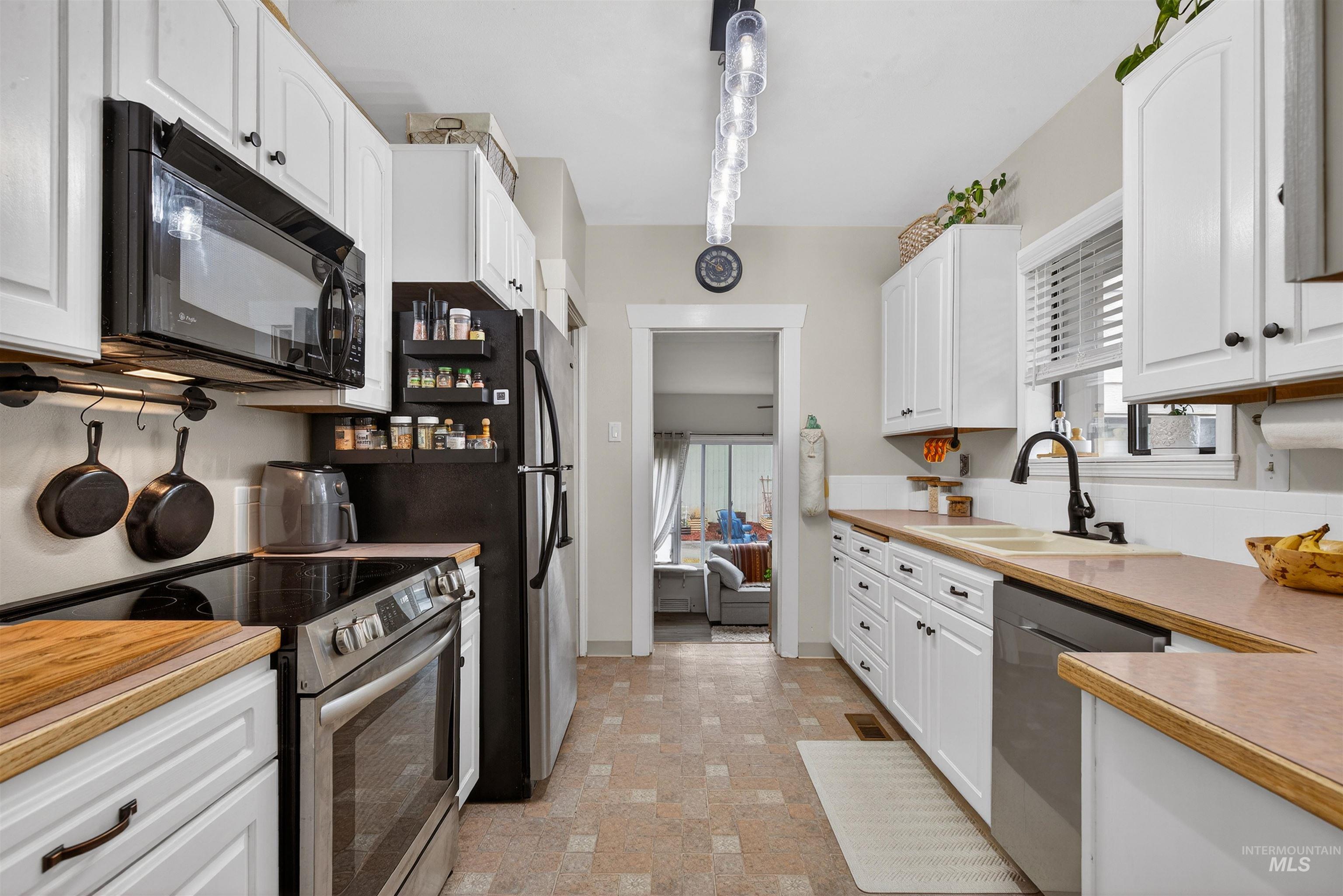 1021 11th Avenue Lewiston, ID 83501 - Photo 11 of 41 Kitchen featuring stainless steel appliances, white cabinetry, and plenty of natural light