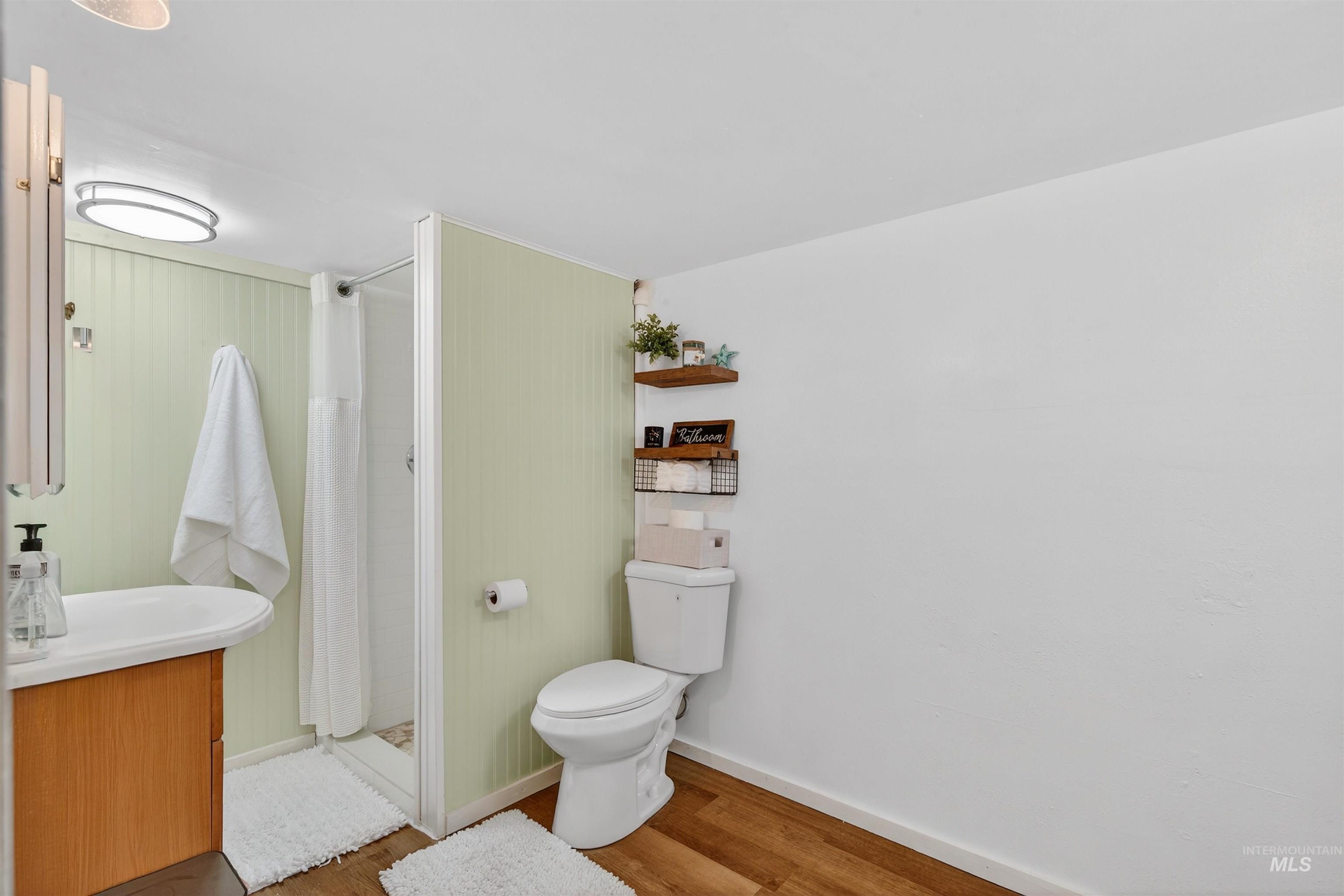 1021 11th Avenue Lewiston, ID 83501 - Photo 24 of 41 Full bathroom featuring vanity, wood finished floors, and a stall shower
