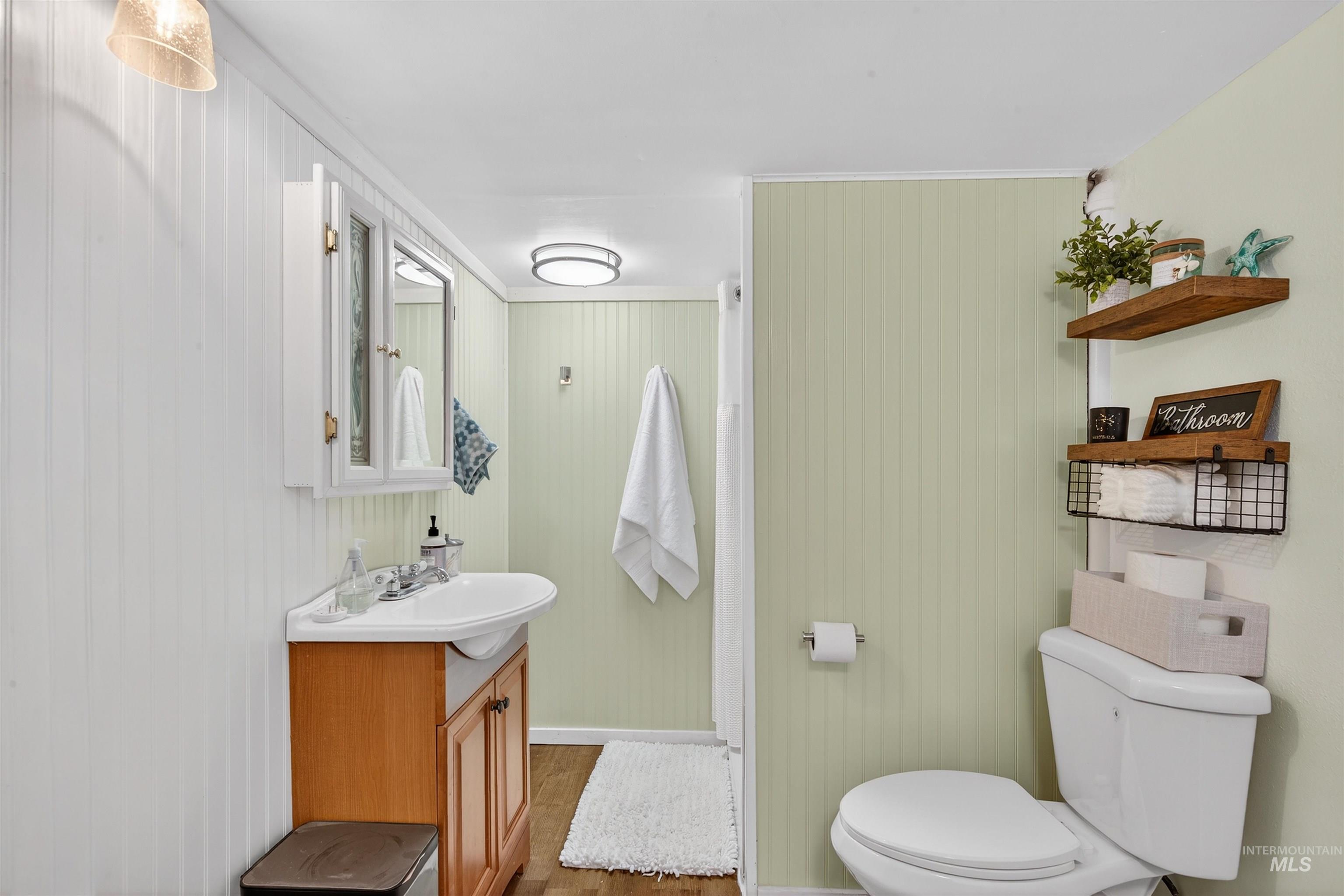 1021 11th Avenue Lewiston, ID 83501 - Photo 25 of 41 Half bath featuring vanity, wood finished floors, and wooden walls