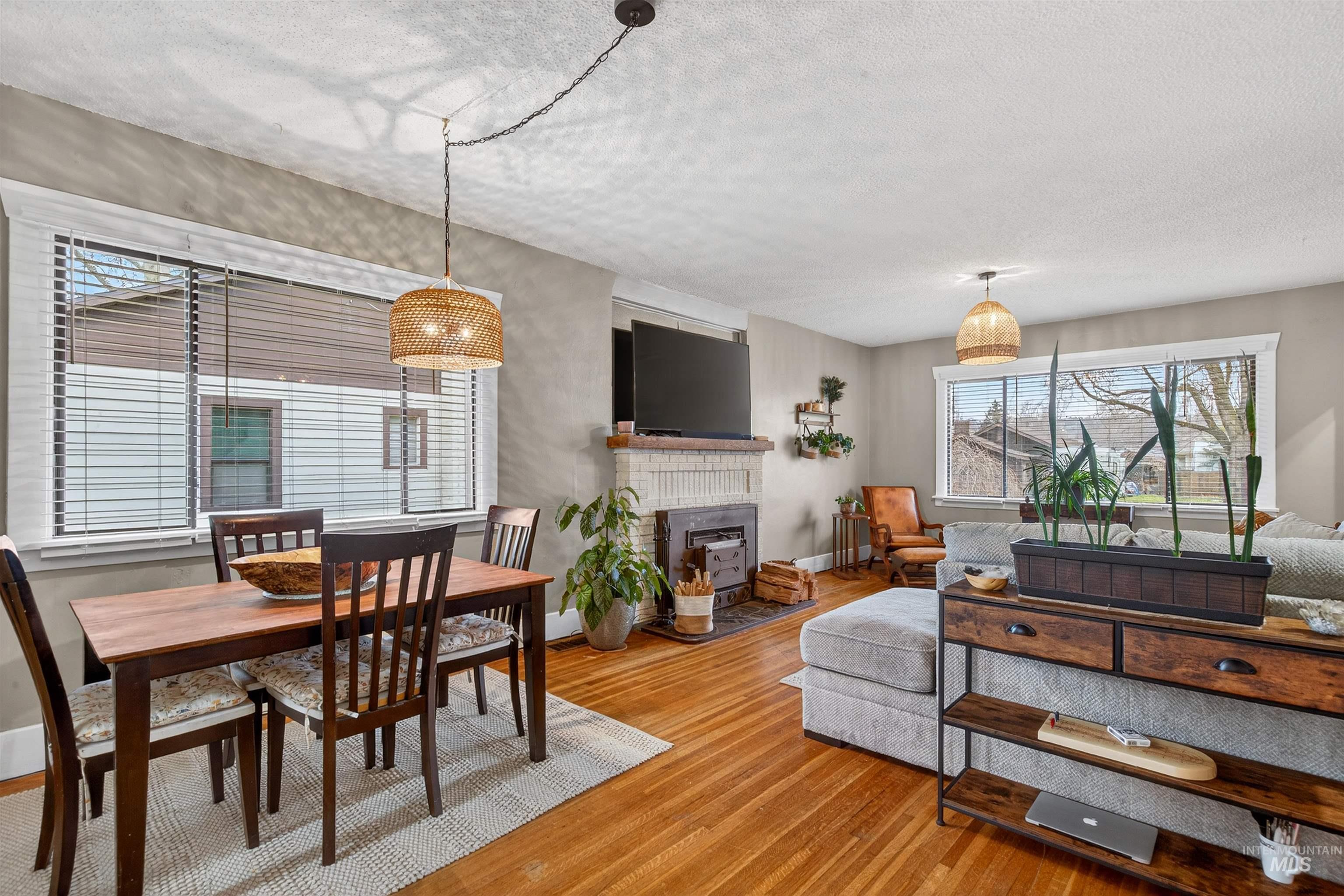 1021 11th Avenue Lewiston, ID 83501 - Photo 9 of 41 Dining area featuring wood finished floors, a fireplace, and a textured ceiling