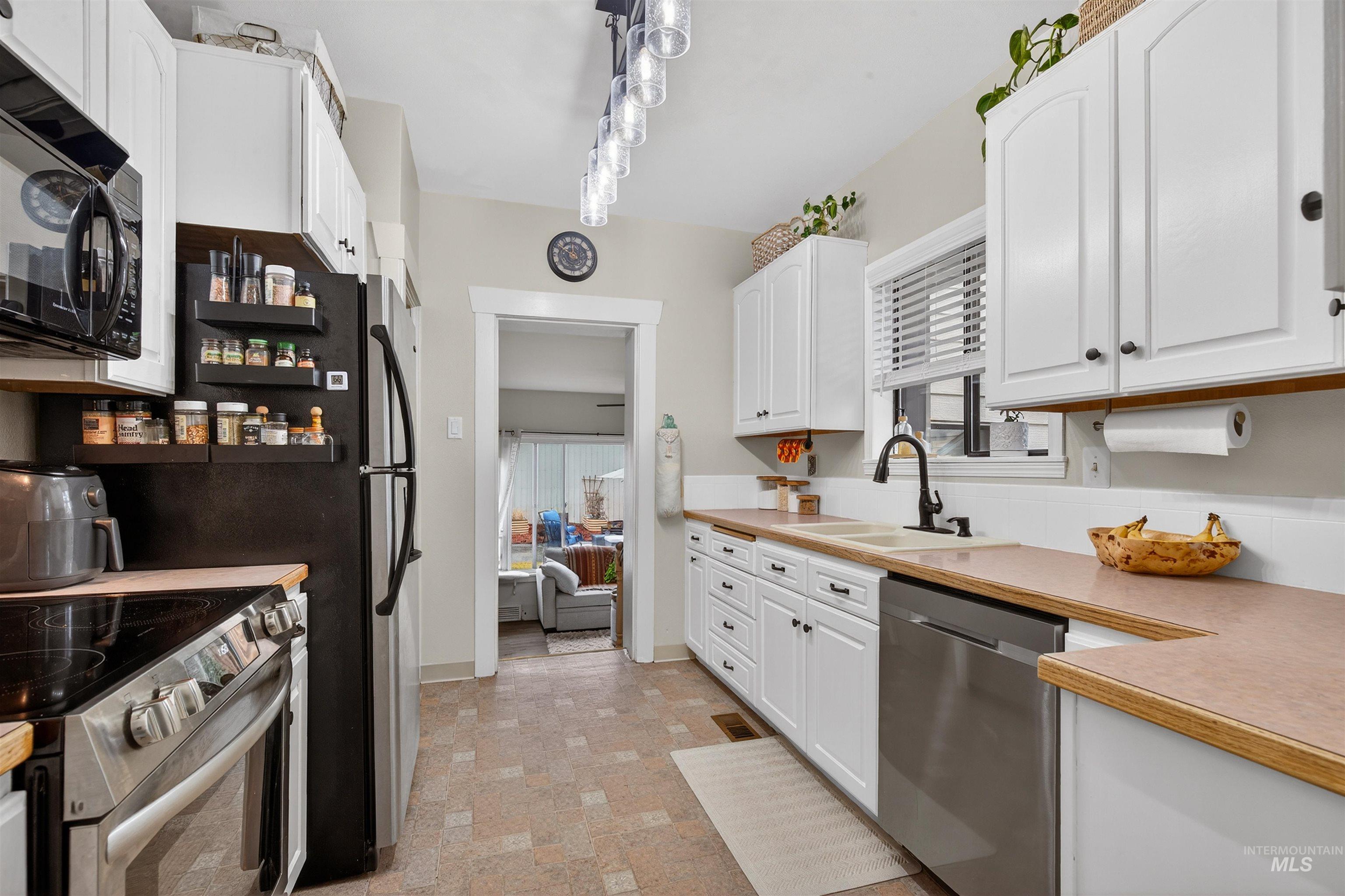 1021 11th Avenue Lewiston, ID 83501 - Photo 10 of 41 Kitchen featuring appliances with stainless steel finishes, white cabinetry, light countertops, and healthy amount of natural light