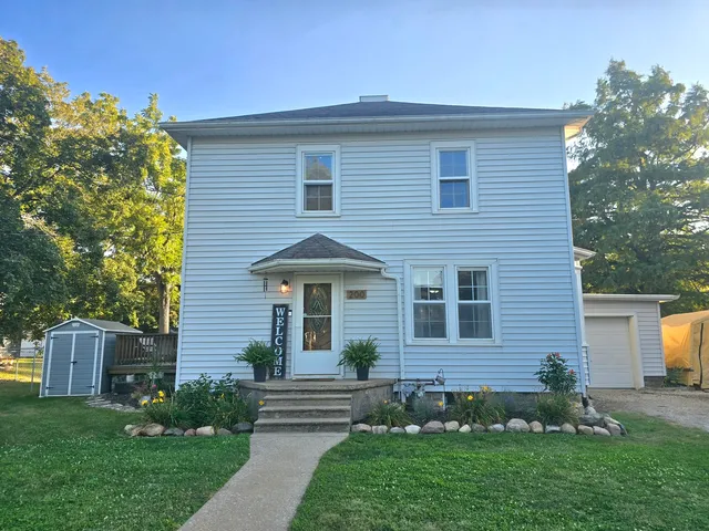 a front view of a house with a garden and plants