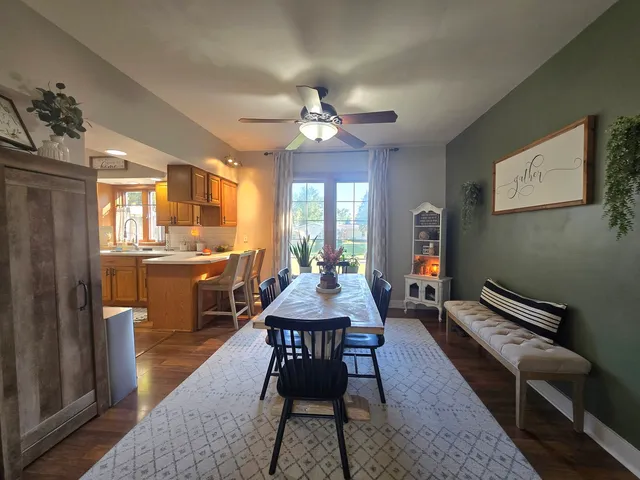 a dining room with a table chairs and a kitchen view