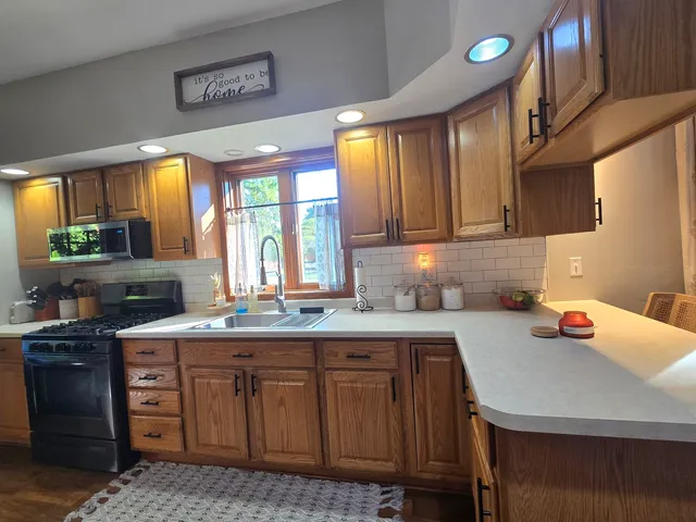 a kitchen with a sink a stove cabinets and a window
