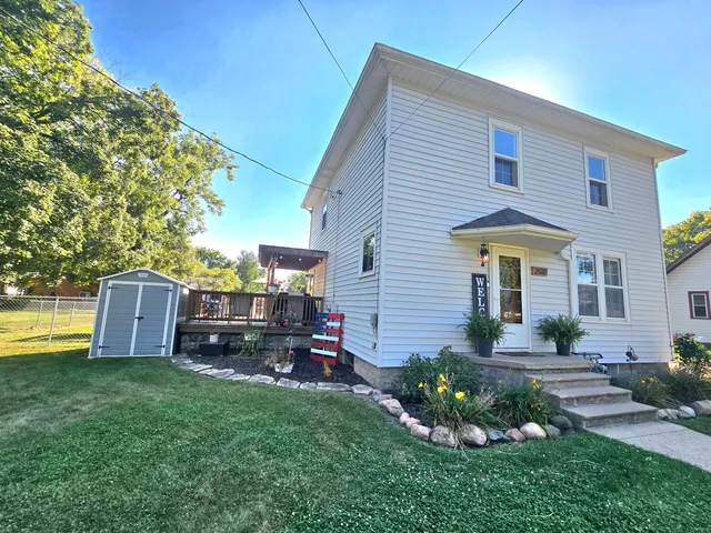 a front view of house with a garden and deck
