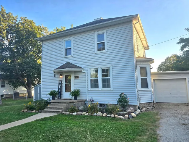 a front view of a house with a garden and plants