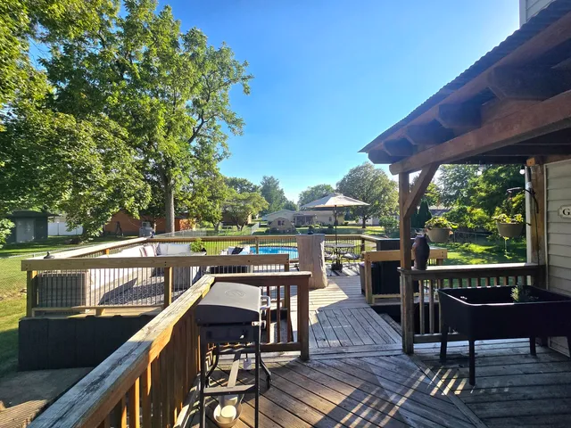 a view of a balcony with wooden floor and outdoor seating