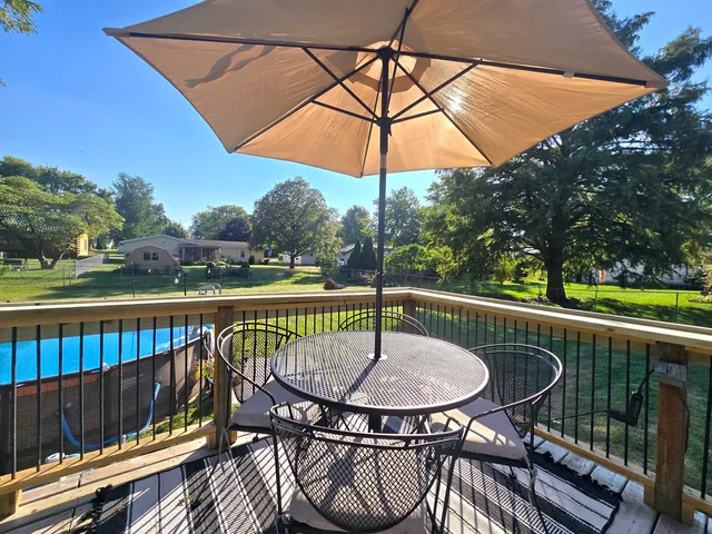 a view of house with roof deck and furniture