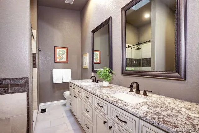 a bathroom with a granite countertop sink and a mirror