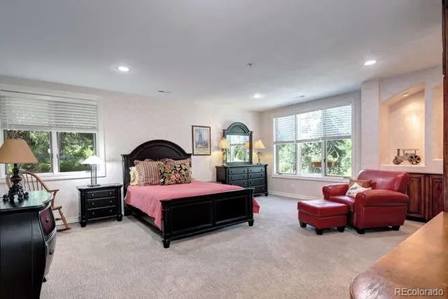 a bedroom with furniture and large windows