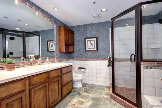 a bathroom with a double vanity sink toilet and shower