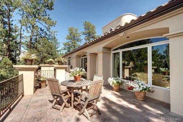 a view of a patio with dining table and chairs with wooden fence