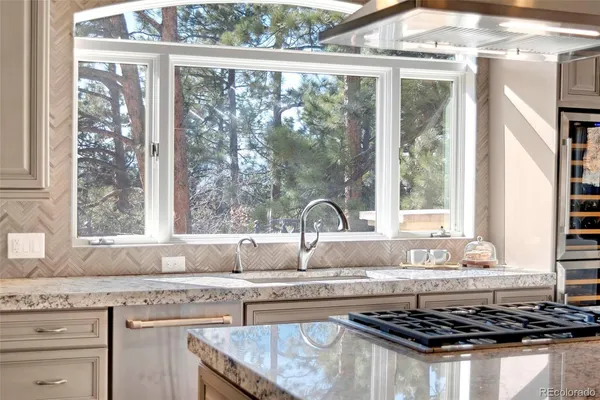 a kitchen with granite countertop a sink a stove and wooden cabinets