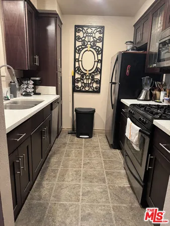 a kitchen with stainless steel appliances a stove a sink and a refrigerator