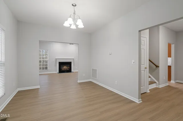 an empty room with wooden floor and fireplace