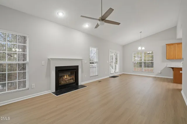 a view of an empty room with a fireplace and a window