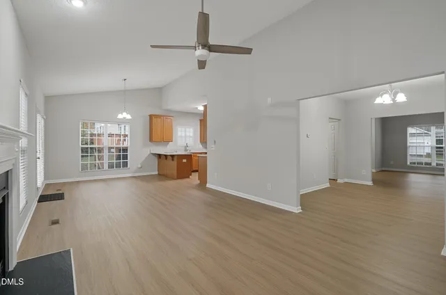 a view of an empty room with a fireplace and a window