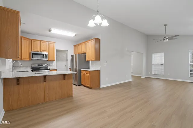 a kitchen with stainless steel appliances granite countertop a sink cabinets and wooden floor