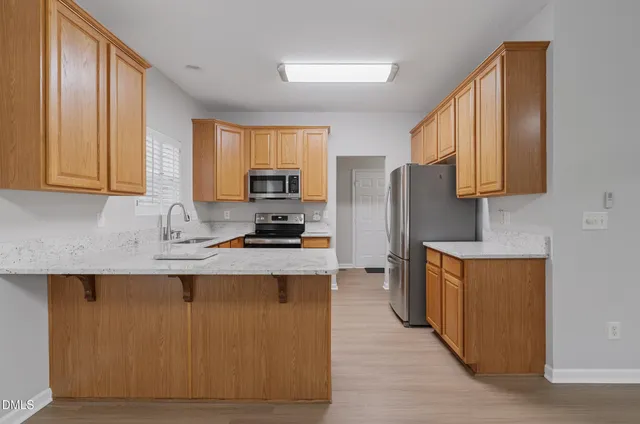 a kitchen with stainless steel appliances granite countertop a stove a sink a refrigerator a microwave and cabinets