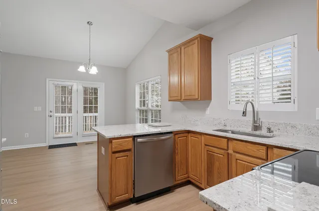 a kitchen filled counter top space a sink wooden floor and window