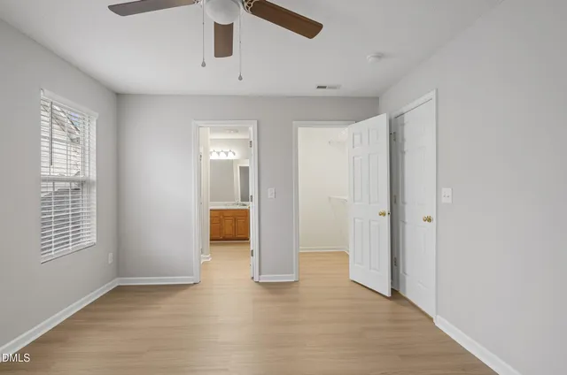 a view of a big room with wooden floor and windows