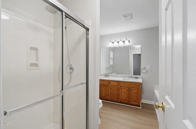 a bathroom with a double vanity sink mirror and shower