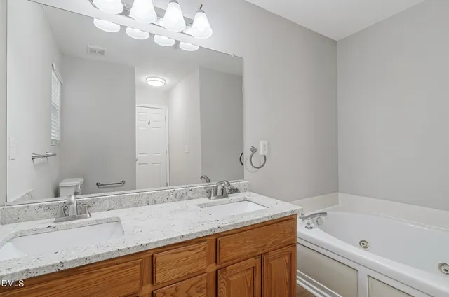 a bathroom with a granite countertop sink a large mirror and a bathtub