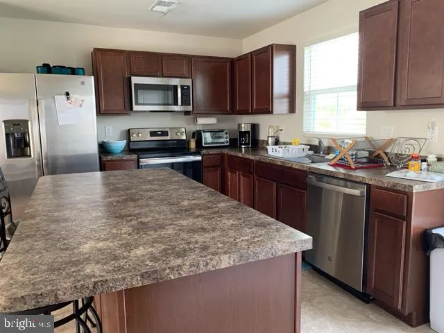 a kitchen with a sink a microwave a refrigerator and cabinets