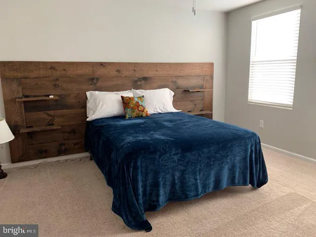 a bed sitting in a bedroom next to a window