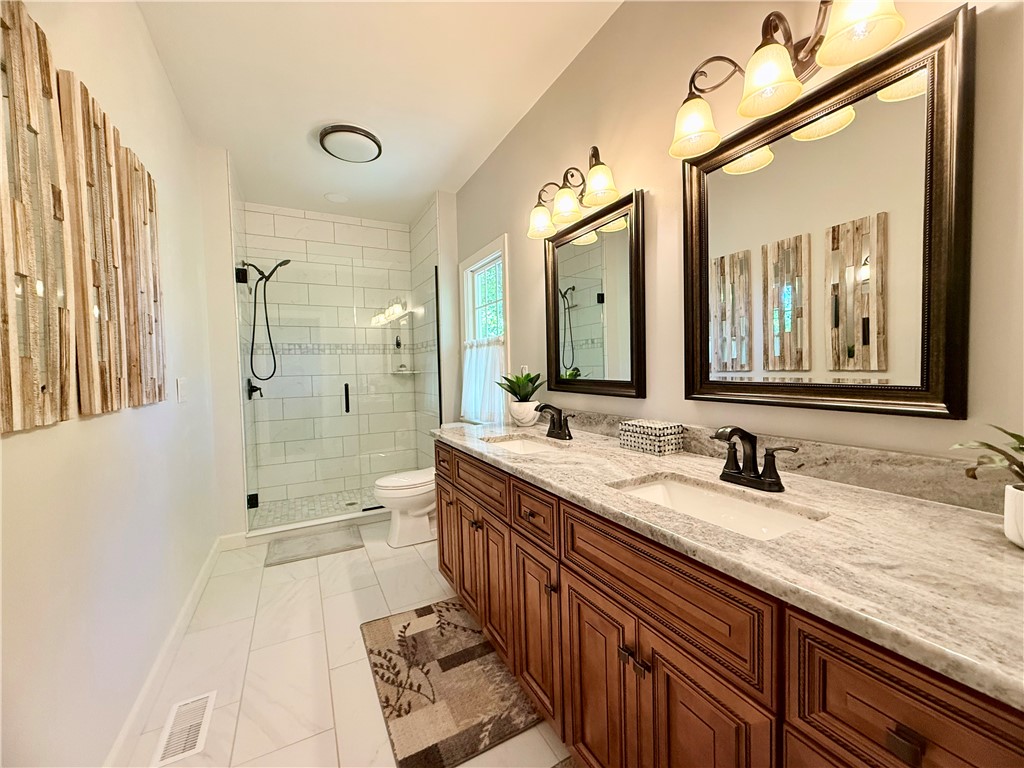 10 Captain Lane Salem, SC 29676 - Photo 15 of 28 This spacious master bathroom offers a double vanity and a glass-enclosed shower, creating a bright and functional space.