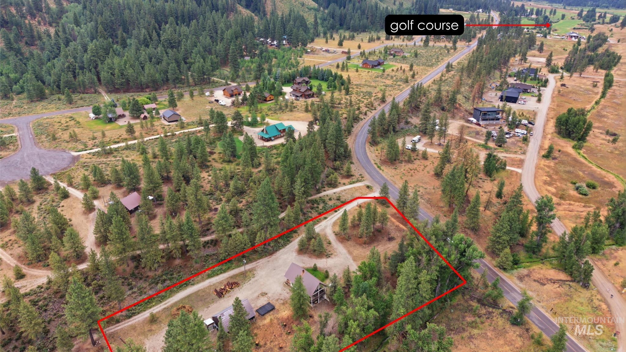 3980 North Pine-Featherville Road Mountain Home, ID 83647 - Photo 5 of 35 Aerial view showcasing a treed lot with a residential structure, bordered by a paved road