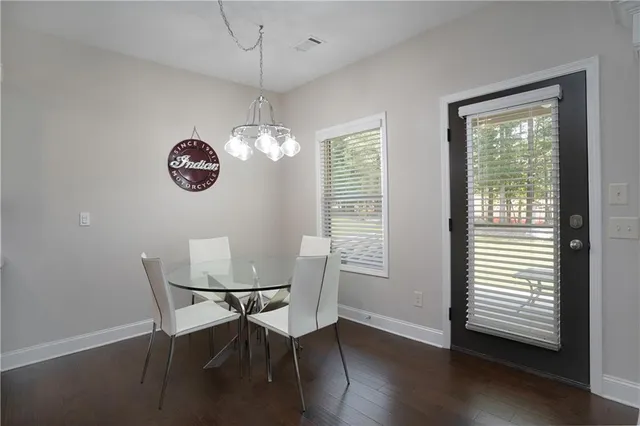 a view of a dining room with furniture a chandelier and wooden floor