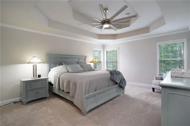 a spacious bedroom with a bed a window and a chandelier