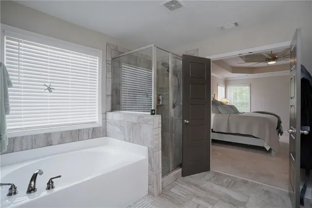 a en suite spacious bathroom with a tub shower and bedroom
