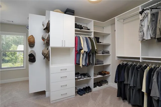 a view of walk in closet with clothes and shoes