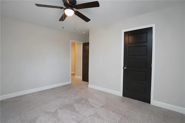 an empty room with closet and a ceiling fan
