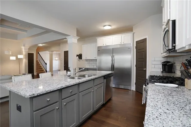 a kitchen with stainless steel appliances granite countertop a sink stove and refrigerator