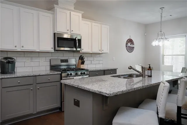 a kitchen with granite countertop a sink a stove and cabinets
