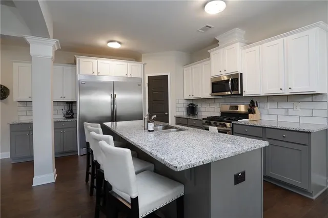 a kitchen with kitchen island granite countertop a sink cabinets and refrigerator