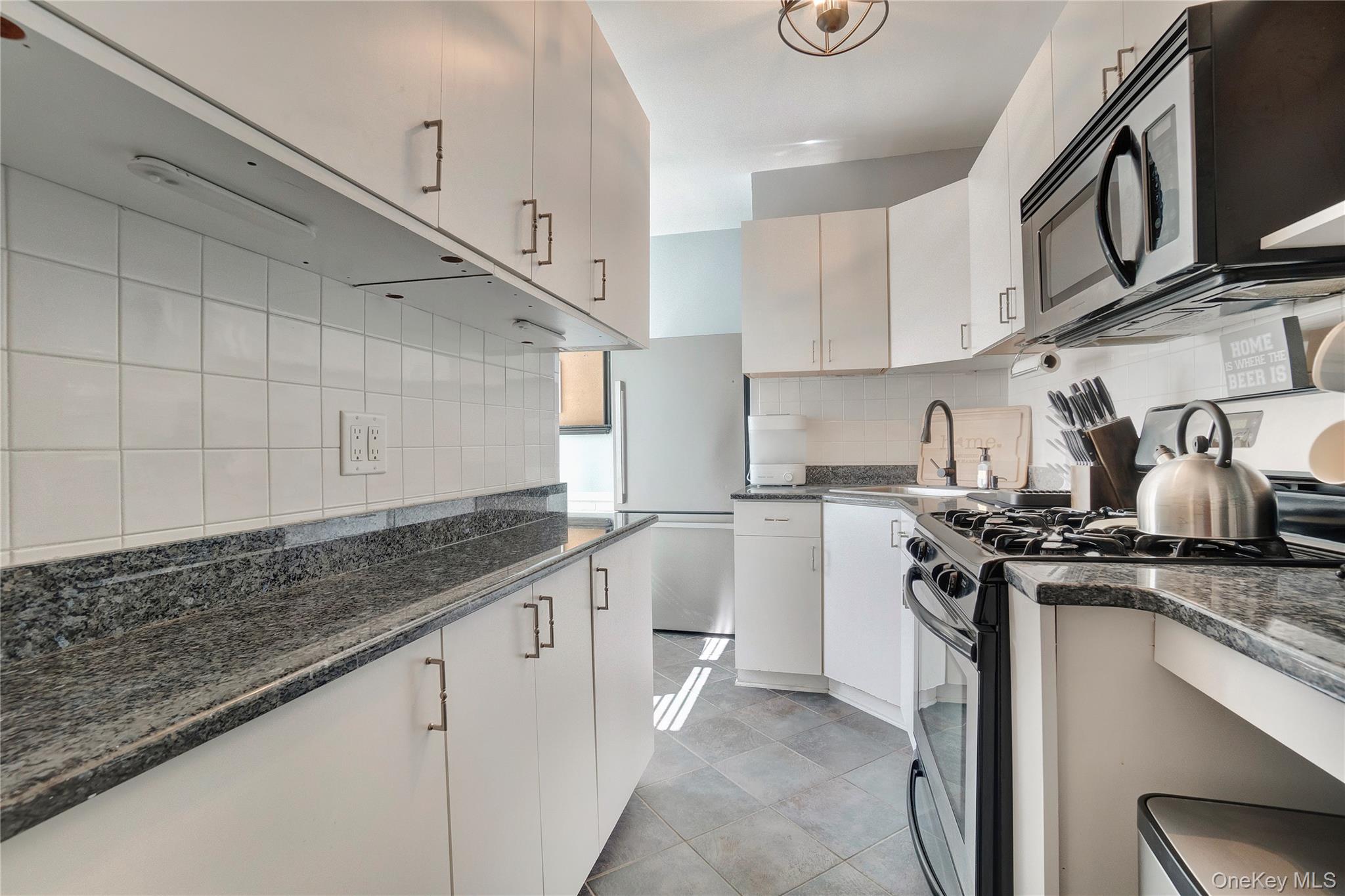 138-11 Beach Channel Drive, Unit C6 Queens, NY 11694 - Photo 9 of 12 a kitchen with stainless steel appliances granite countertop a stove a sink and a refrigerator